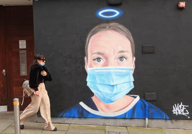 A woman walks past a mural in Manchester city centre.
