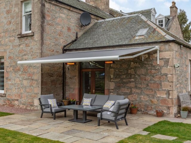 Paved terrace with retractable awning and wall heaters.