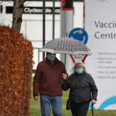 People walk passed a Vaccination Centre sign at the Royal Highland Show ground in Edinburgh, where lockdown measures introduced on January 5 for mainland Scotland remain in effect until at least the end of February. Picture date: Thursday February 4, 2021.