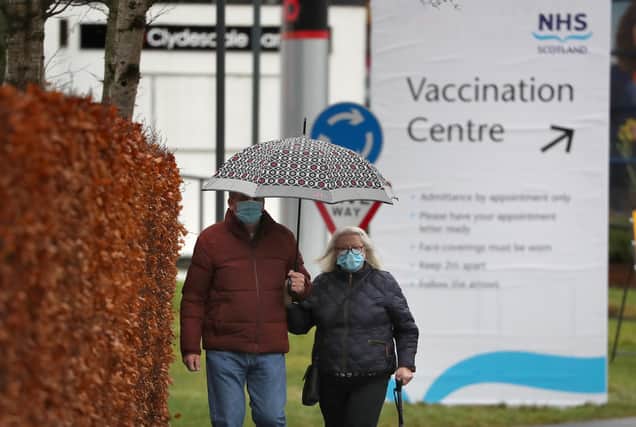 People walk passed a Vaccination Centre sign at the Royal Highland Show ground in Edinburgh, where lockdown measures introduced on January 5 for mainland Scotland remain in effect until at least the end of February. Picture date: Thursday February 4, 2021.
