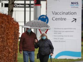 People walk passed a Vaccination Centre sign at the Royal Highland Show ground in Edinburgh, where lockdown measures introduced on January 5 for mainland Scotland remain in effect until at least the end of February. Picture date: Thursday February 4, 2021.