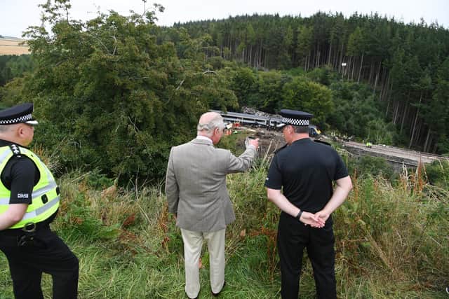 The Prince of Wales looks over at the scene of the ScotRail train derailment near Stonehaven, Aberdeenshire, which cost the lives of three people on Wednesday. (Credit: Ben Birchall/PA Wire)