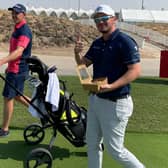 Playing a practice round together, Grant Forrest pulls Ewen Ferguson's trolley to allow his fellow Scot to grab a bite to eat in a practice round at Yas Links.