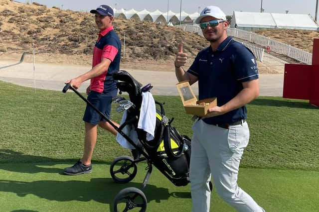Playing a practice round together, Grant Forrest pulls Ewen Ferguson's trolley to allow his fellow Scot to grab a bite to eat in a practice round at Yas Links.