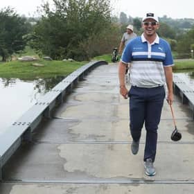Ewen Ferguson shares a laugh as he crosses a bridge at The Club at Steyn City during the Steyn City Championship. Picture: Warren Little/Getty Images.