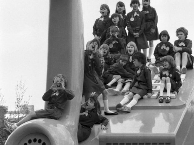 A troop of Brownies sitting on a BT giant telephone at the Glasgow Garden Festival in May 1988.