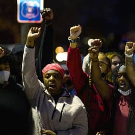 Demonstrators chant around a chalk circle that says Justice for Daunte Wright on April 11, 2021 in Brooklyn Center, Minnesota. Protesters took to the streets after 20 year old Daunte Wright was shot and killed during a traffic stop by members of the Brooklyn Center police.