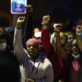 Demonstrators chant around a chalk circle that says Justice for Daunte Wright on April 11, 2021 in Brooklyn Center, Minnesota. Protesters took to the streets after 20 year old Daunte Wright was shot and killed during a traffic stop by members of the Brooklyn Center police.
