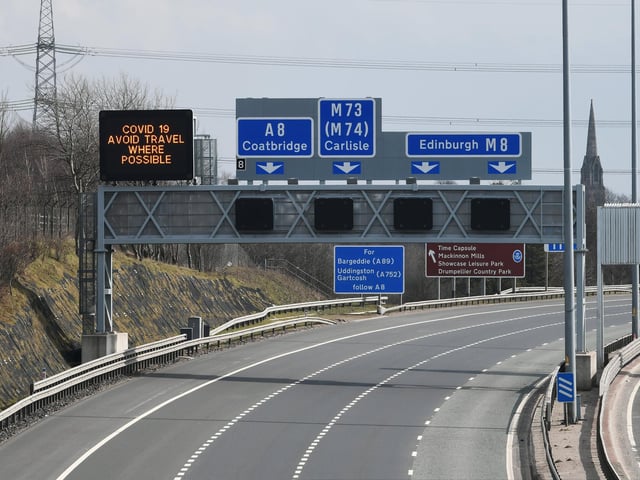 A sign above Glasgow's M8 read 'Avoid travel where possible'. Picture: John Devlin