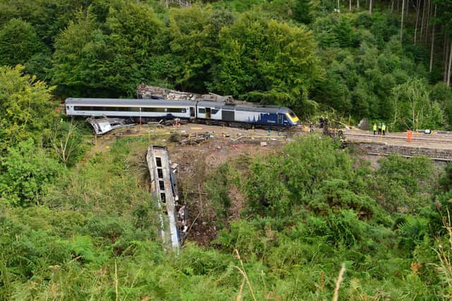 Members of the emergency services inspect the debris and derailed carriages at the scene of the train crash near Stonehaven on August 12 last year. Picture: Ben Birchall/AFP/Getty