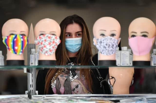 A shopper wearing a face mask visits a retail outlet in Glasgow. A plan is due to be published today on attracting inward investment to Scotland in areas including retail. Picture: John Devlin
