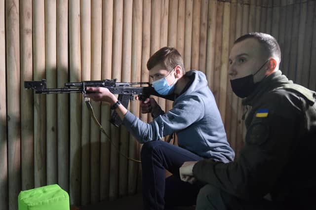 A military instructor teaches a school pupil how to fire a Kalashnikov rifle during a National Guard training session in the Ukrainian city of Lviv on Tuesday (Picture: Yuriy Dyachyshyn/AFP via Getty Images)