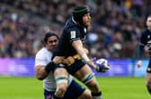 Scotland's Jack Dempsey offloads against France under pressure from Posolo Tuilagi. (Photo by Craig Williamson / SNS Group)