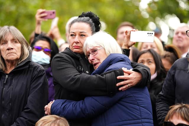 Members of the public reacts as the State Gun Carriage carries the coffin of Queen Elizabeth II, draped in the Royal Standard with the Imperial State Crown and the Sovereign's orb and sceptre, in the Ceremonial Procession following her State Funeral at Westminster Abbey, London. Picture date: Monday September 19, 2022.