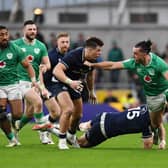 James Lowe of Ireland is tackled by Blair Kinghorn and Huw Jones of Scotland.