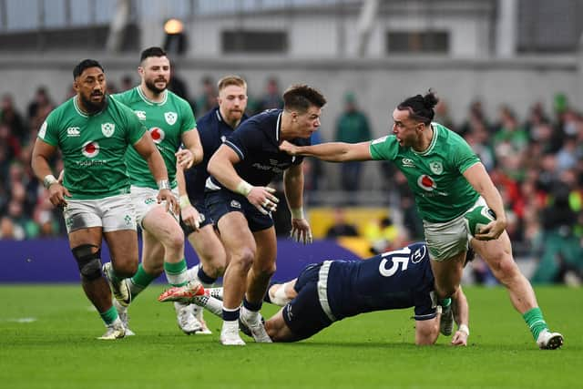 James Lowe of Ireland is tackled by Blair Kinghorn and Huw Jones of Scotland.