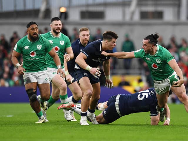 James Lowe of Ireland is tackled by Blair Kinghorn and Huw Jones of Scotland.