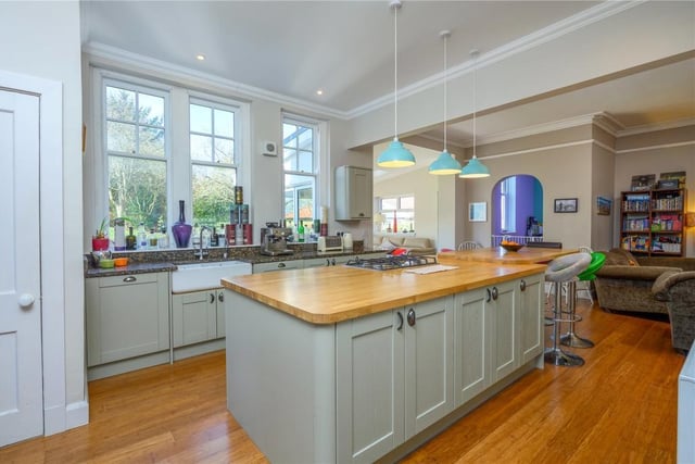 The kitchen area is fitted with side units and granite surfaces, as well as a central island, while there is also a double Belfast sink, and a shelved pantry.