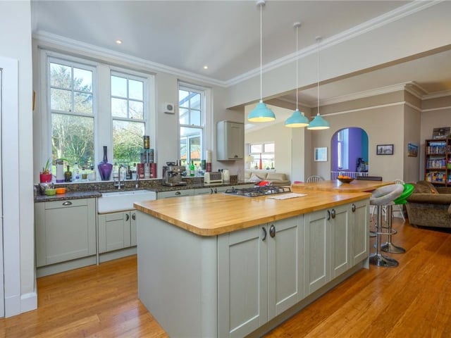 The kitchen area is fitted with side units and granite surfaces, as well as a central island, while there is also a double Belfast sink, and a shelved pantry.