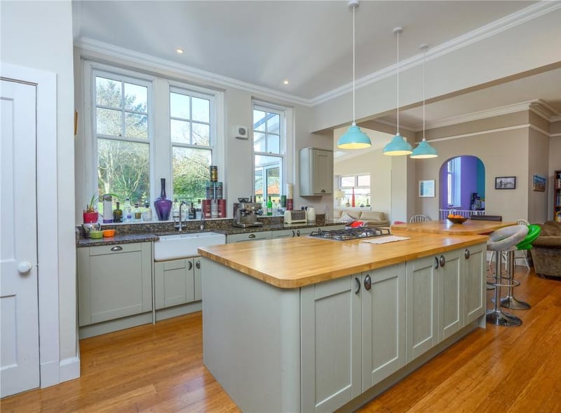The kitchen area is fitted with side units and granite surfaces, as well as a central island, while there is also a double Belfast sink, and a shelved pantry.