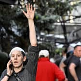 A wounded woman waves while speaking on the phone as rescuers and volunteers work to rescue people from under rubble after a Russian missile strike to a pizzeria in Kramatorsk. Picture: Genya Savilov/AFP via Getty Images