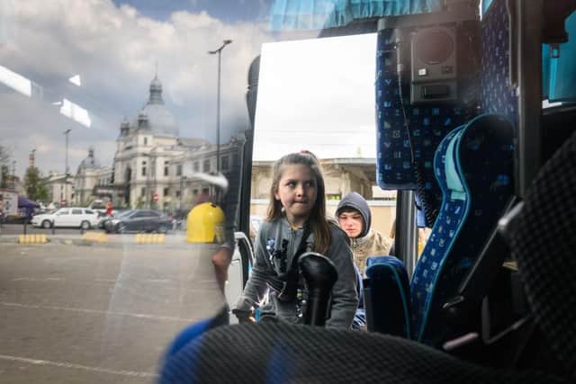 A young girl climbs aboard a bus bound for Przemyśl in Poland, carrying refugees from regions of Southern and Eastern Ukraine, including Mariupol.