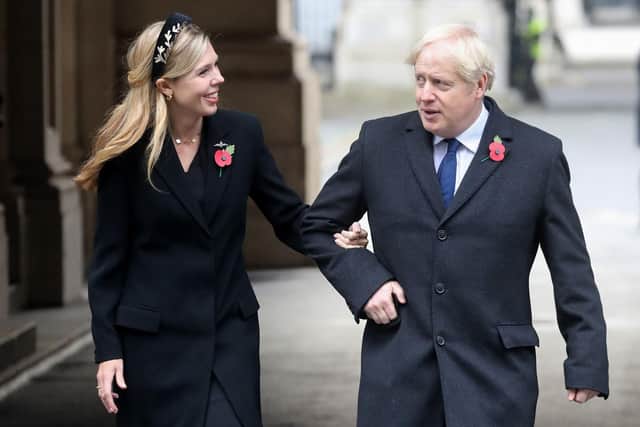 In this file photo taken on November 8, 2020 Britain's Prime Minister Boris Johnson (R) and his parter Carrie Symonds (L) meet veterans at the Remembrance Sunday ceremony at the Cenotaph on Whitehall in central London - Johnson married his fiancee Carrie Symonds married in a "secret ceremony" on May 29, 2021, UK media reports said.