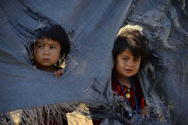Afghan children look on from their tent at a camp for refugees in Injil district of Herat province in 2018. They were forced to flee their homes not by war but by the worst drought in living memory (Picture: Hoshang Hashimi/AFP via Getty Images)