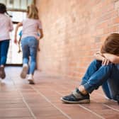 A schoolboy sits in a classroom corridor