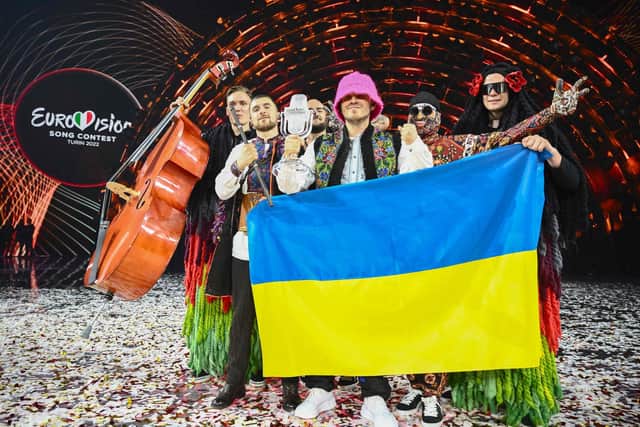 Members of the band Kalush Orchestra pose onstage with the winner's trophy and Ukraine's flags after winning Eurovision 2022 on behalf of Ukraine. Photo: MARCO BERTORELLO/AFP via Getty Images.