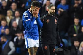 Rangers defender Connor Goldson leaves the pitch in pain during the match against Liverpool.