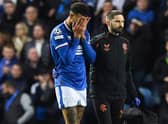Rangers defender Connor Goldson leaves the pitch in pain during the match against Liverpool.