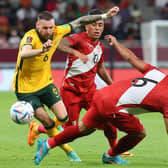 Australia's forward Martin Boyle (L) is tackled by Peru's defender Miguel Trauco (R) during the FIFA World Cup 2022 inter-confederation play-offs match between Australia and Peru. (Photo by KARIM JAAFAR / AFP) (Photo by KARIM JAAFAR/AFP via Getty Images)