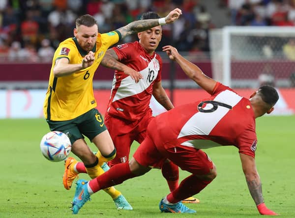 Australia's forward Martin Boyle (L) is tackled by Peru's defender Miguel Trauco (R) during the FIFA World Cup 2022 inter-confederation play-offs match between Australia and Peru. (Photo by KARIM JAAFAR / AFP) (Photo by KARIM JAAFAR/AFP via Getty Images)