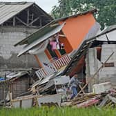 A man makes his way past ruins of earthquake-damaged houses in Cianjur, West Java, Indonesia Tuesday, Nov. 22, 2022. The earthquake has toppled buildings on Indonesia's densely populated main island, killing a number of people and injuring hundreds. (AP Photo/Tatan Syuflana)