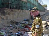 A Taliban fighter stands guard at the site of the August 26 twin suicide bombs, which killed scores of people including 13 US troops, at Kabul airport