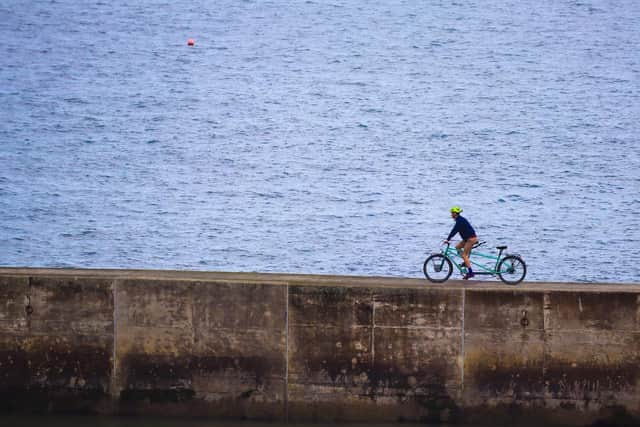 Xani cycling along a pier