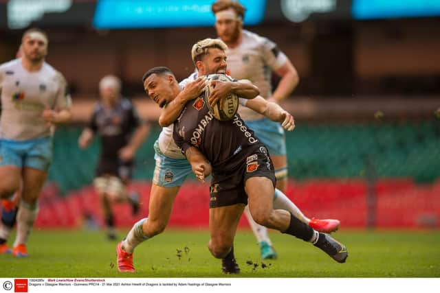 Dragons' Ashton Hewitt feels the full force of Glasgow's Adam Hastings. Picture: Mark Lewis/Huw Evans/Shutterstock