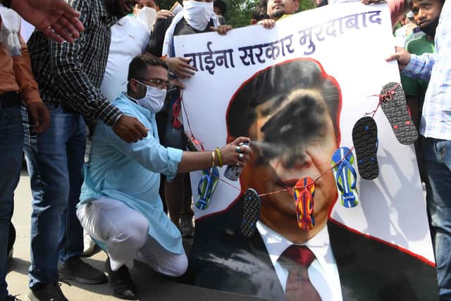 Activists of Bharatiya Janata Party (BJP) spray black paint on a poster depicting Chinese President Xi Jinping during a protest in Amritsar after an India-China border clash that left 20 troops dead (Picture: Narinder Nanu/AFP via Getty Images)