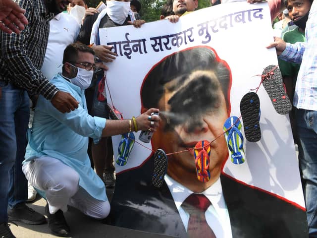 Activists of Bharatiya Janata Party (BJP) spray black paint on a poster depicting Chinese President Xi Jinping during a protest in Amritsar after an India-China border clash that left 20 troops dead (Picture: Narinder Nanu/AFP via Getty Images)