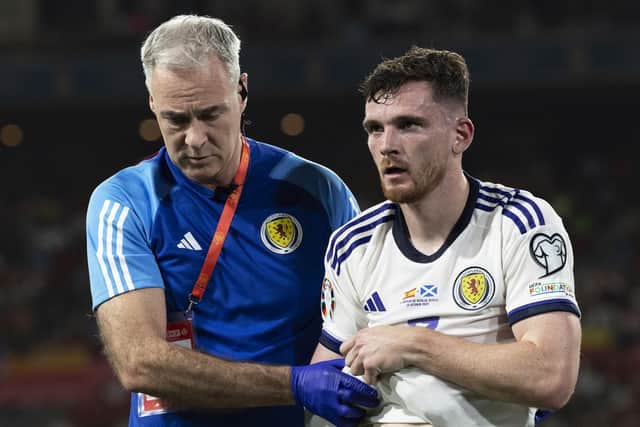 Scotland's Andy Robertson goes off injured against Spain.
