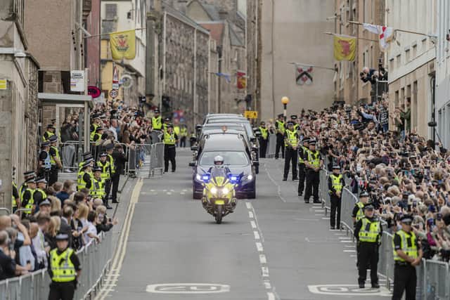 The hearse carrying the coffin of Queen Elizabeth II, draped with the Royal Standard of Scotland, passing along the Royal Mile, Edinburgh, as it continued its journey to the Palace of Holyroodhouse from Balmoral