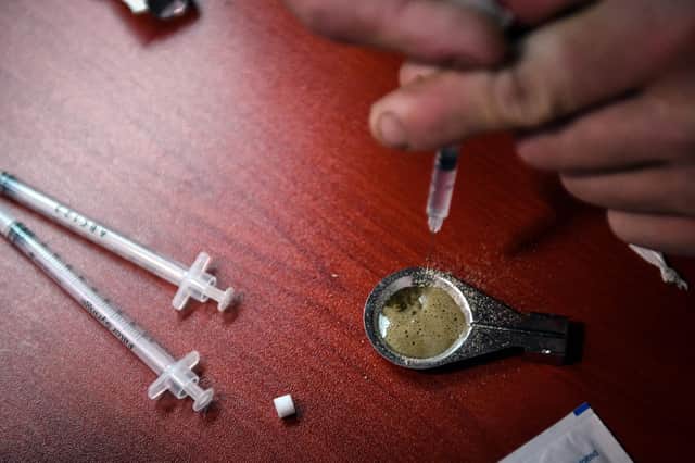 A drug user prepares and injects heroin inside former drug user-turned-drug policy campaigner Peter Krykant's "Safe Consumption" van, a mobile sterile drugs consumption facility he runs, in Glasgow in September 2020 (Photo by ANDY BUCHANAN/AFP via Getty Images)