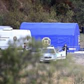 A police officer stands by a car and a tent near Barragem do Arade, Portugal