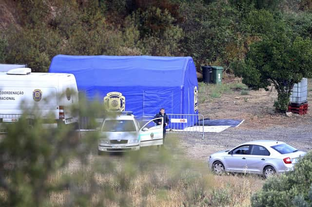 A police officer stands by a car and a tent near Barragem do Arade, Portugal