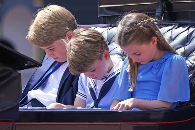 Prince George (left), Prince Louis and Princess Charlotte bow their heads as they receive a salute as the Royal Procession returns to Buckingham Palace