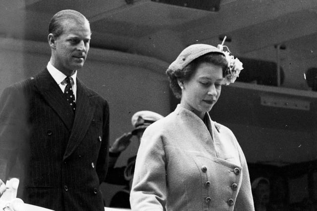 Queen Elizabeth II and the Duke of Edinburgh walk down the gangway of the Royal Yacht Britannia at Aberdeen in August 1955.