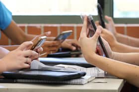 Students on phones at school table
