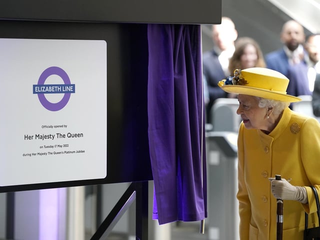 Queen Elizabeth II unveils a plaque to mark the Elizabeth line's official opening at Paddington station in London, to mark the completion of London's Crossrail project.