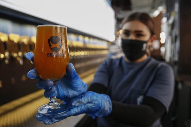 A staff member at BrewDog Tower Hill, London, holds up a Pineapple Coconut Crumb beer as they prepare for 'Super Saturday', with pubs reopen across England.
